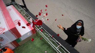 A woman throws rose petals on the coffins during funeral of children killed in a strike on 28 February on a girls' elementary school in Minab, Iran. Photograph: Amirhossein Khorgooei/AP