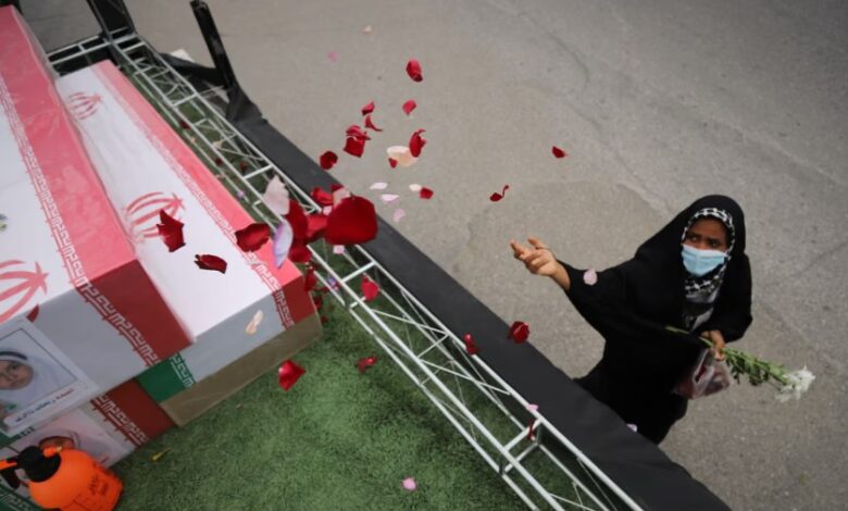A woman throws rose petals on the coffins during funeral of children killed in a strike on 28 February on a girls' elementary school in Minab, Iran. Photograph: Amirhossein Khorgooei/AP